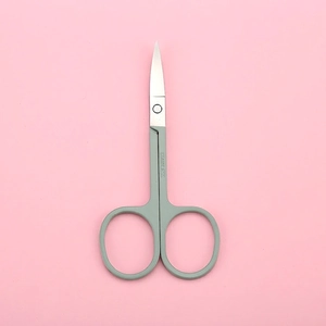 Precision stainless steel grooming scissors with ergonomic gray handles on pink background