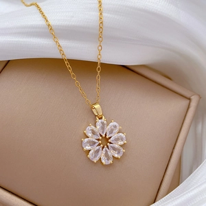 Collier fleur rotatif en acier titane doré avec zircons sur soie blanche et cuir
