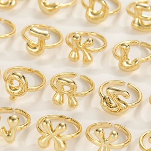 Detailed top view of various 18K gold letter rings J K L O P S W X Y on white background