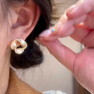 Elegant 14K gold plated flower stud earrings with pearls worn by a model