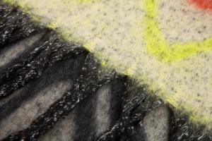 Close-up of thick mohair-style scarf showing black fringe and textured wave jacquard pattern