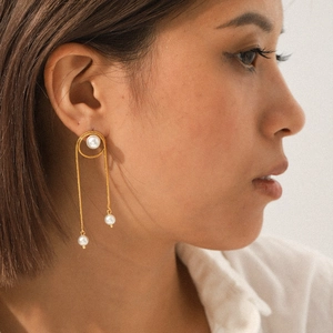 Elegant gold snake chain tassel earrings with white pearls for women on model