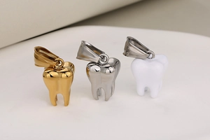 Makroaufnahme der 3D-Zahnanhaenger in Gold, Silber und Weiß aus Edelstahl-Finish