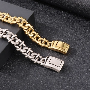 Macro detail of industrial curb chain bracelet with square clasp in gold and silver