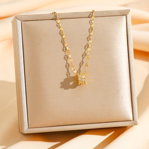 Elegant gold cylinder pendant necklace with zircon pavé on champagne silk background