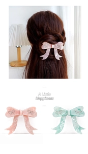 Detail of acetate bow hair clips with marble texture and rhinestone butterfly accents