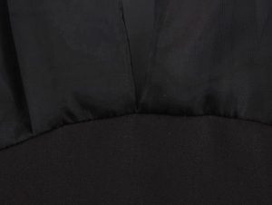 Détail en gros plan montrant la texture du tissu noir haute densité et les coutures de qualité
