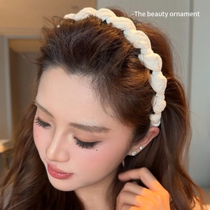 Serre-tête tressé en tissu blanc porté par un mannequin au design torsadé