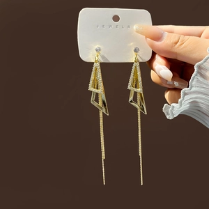 Elegant gold-tone geometric tassel earrings with white crystal dangles and chain details