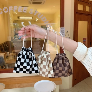 Tres bolsas de punto con cordón y diseño de cuadros en un acogedor café