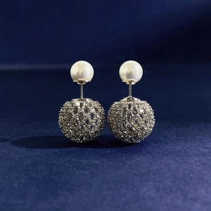 Classic double-sided pearl earrings with silver crystal-studded hollow sphere on blue velvet