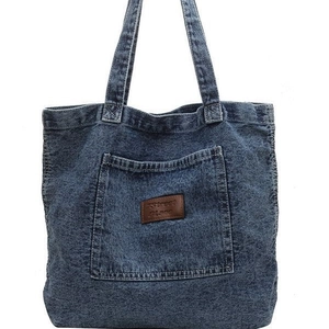 Large capacity washed denim tote bag in dark blue with front pocket and leather logo