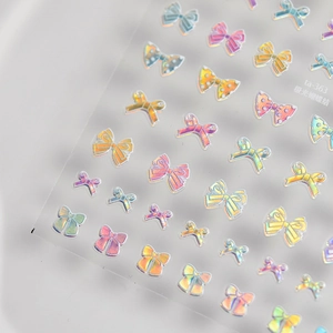 Macro detail of aurora holographic 3D bow nail art stickers with various textured patterns