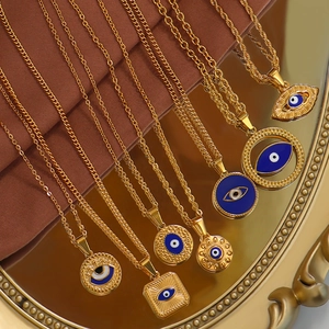 Detail shot of assorted gold evil eye pendants on chains displayed on a golden tray