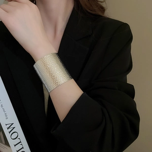 Detail of silver textured wide cuff bracelet with honeycomb hammer pattern on a model