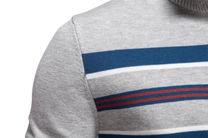 Detail of grey men's knit sweater with blue, white, and red striped texture on shoulder