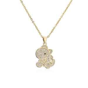 Macro detail of gold-plated dinosaur pendant with shimmering cubic zirconia inlay
