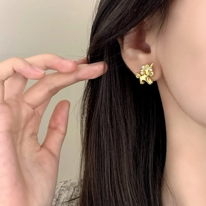 Close-up of 18k gold plated unicorn stud earrings with zircon crystals on ear