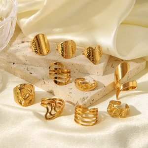 Collection of irregular gold geometric stainless steel rings on silk and stone base
