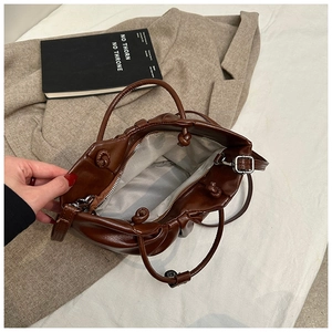 Detail view of the deep brown cloud bag interior showing smooth lining and zipper pocket