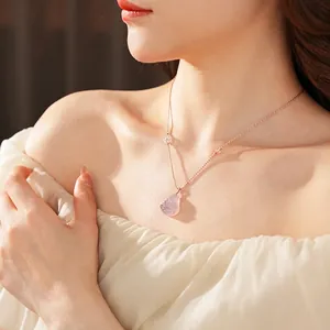 Pink chalcedony Buddha pendant necklace on a delicate chain worn by a female model
