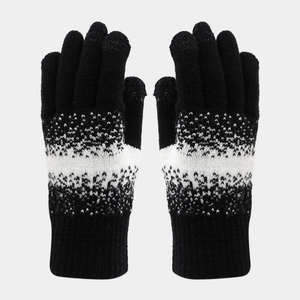 Detail of knitted winter gloves featuring black and white snowflake jacquard pattern