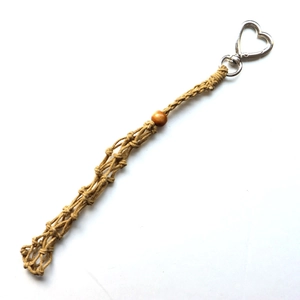 Close-up of woven jute rope bag charm with heart spring clasp and wooden bead detail