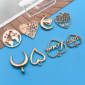 Detailed view of assorted KC gold hollow charms including heart and moon for DIY jewelry