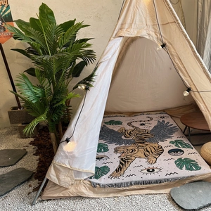 Detail view of bohemian tiger pattern rug inside a stylish cream indoor tent