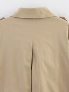 Close-up of the back seam and collar stitching on a khaki short double-breasted trench coat