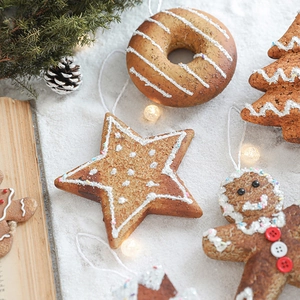 Glittery foam Christmas ornaments including stars and gingerbread shapes in festive snowy setting
