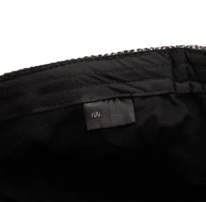 Detail shot of the cotton newsboy cap inner lining showing the 100% cotton care label