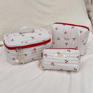 Three-piece quilted cherry print makeup bag set with red zipper details and sturdy handles