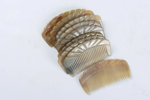Detailed view of carved yak horn combs with natural grain and translucent texture