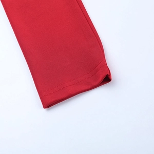 Detailaufnahme des roten Strickkleides mit Fokus auf elastische Textur und Saum