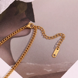 Macro view of 18K gold necklace clasp and extender chain with quality hallmark tag