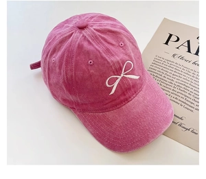 Detailansicht der pinkfarbenen Baumwollkappe mit weißer Schleifenstickerei im Vintage-Look