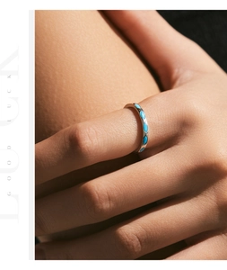 Close-up of minimalist silver stacking ring with turquoise marquise stones on finger