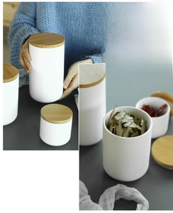 Detail of three white ceramic storage jars with bamboo lids in various sizes for kitchen use