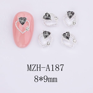 Macro shot of 8x9mm hollow heart nail charm with grey zircon on pink false nails