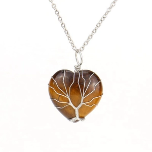 Macro shot of silver wire wrapped tree of life on tiger eye heart stone necklace