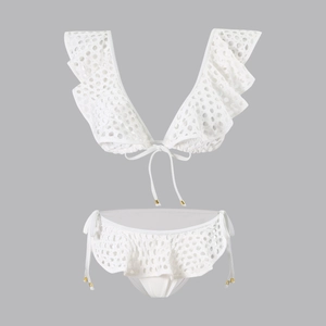 Detail of white crochet bikini set with ruffles and gold metal hardware accents
