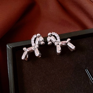 Detailed macro view of 18k gold plated silver balloon dog earrings with zircon insets