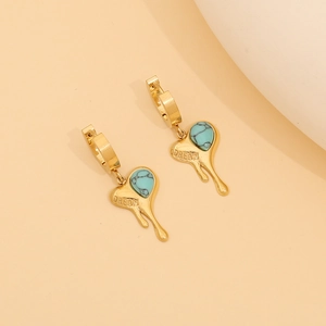 Detail of heart-shaped melting gold earrings with turquoise stone and DREAM engraving