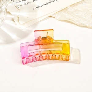 Detail of pink and yellow gradient resin rectangular hair claw with metal spring mechanism
