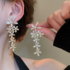 Detailed view of shimmering flower tassel earrings with zircons and silver needle studs
