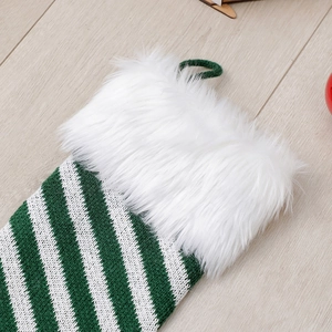 Detail of green and white striped knit Christmas stocking with fluffy white faux fur cuff