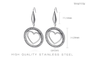 Detail view of silver heart drop earrings with zircon inlay and teardrop charm