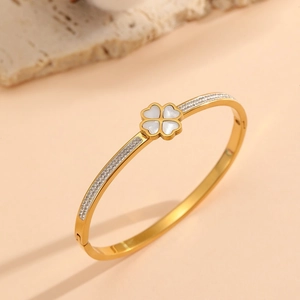 Close-up of gold clover bracelet featuring white mother of pearl and shimmering zircons