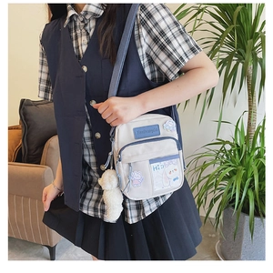 Détails du sac bandoulière en toile avec écussons mignons et peluche décorative